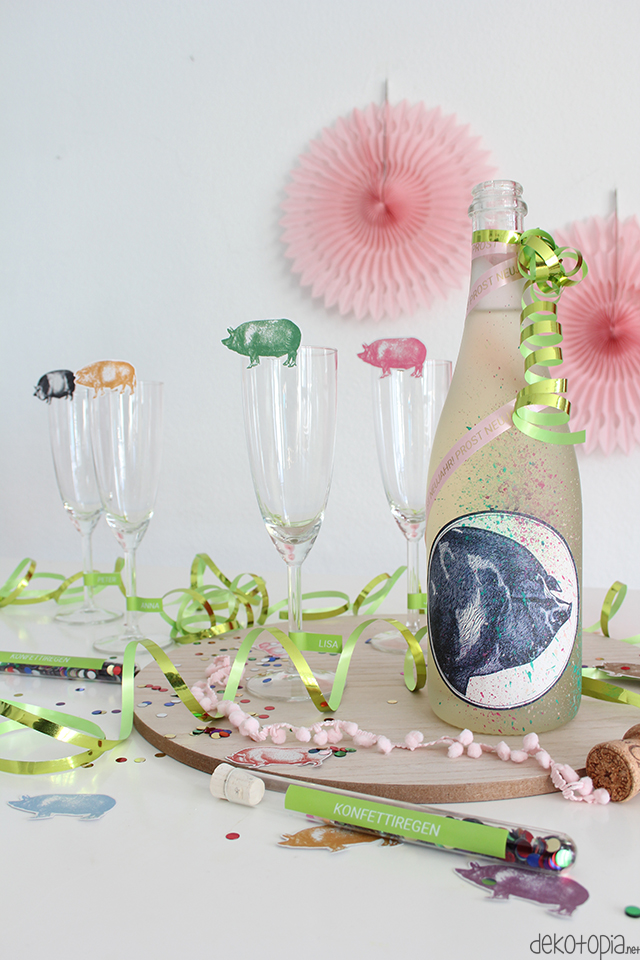 DIY Silvesterdeko mit Schweinen und Schriftbändern: Sektflasche, Konfettiregen und Sektgläser mit Namenschild